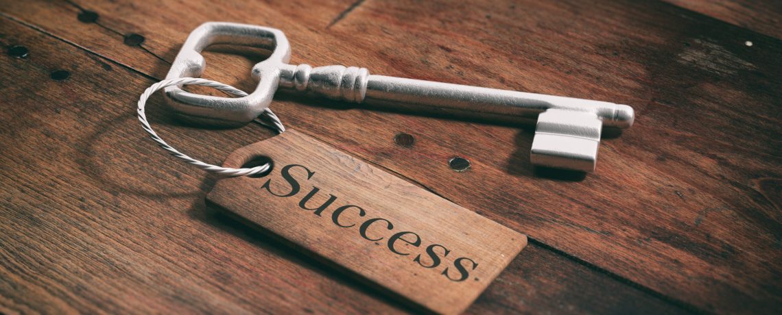 Old metal key with label success on a wooden background. 3d illustration